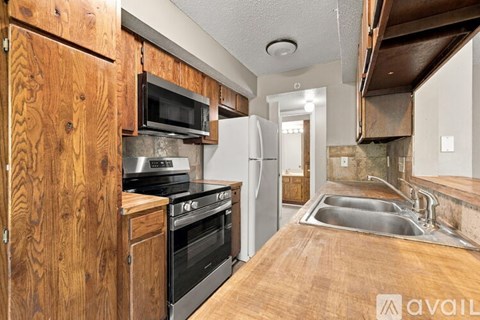 A kitchen with wooden cabinets and stainless steel appliances.