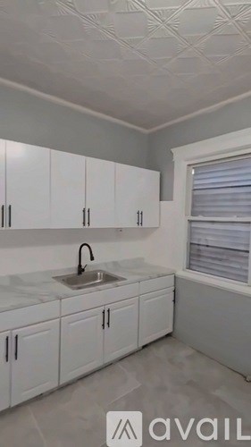 A kitchen with white cabinets and a sink.