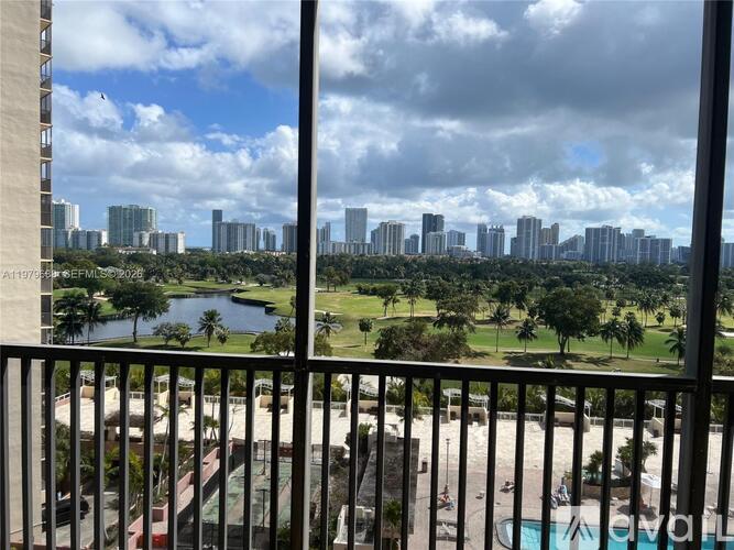 A view from a balcony overlooking a cityscape with a pool in the foreground.