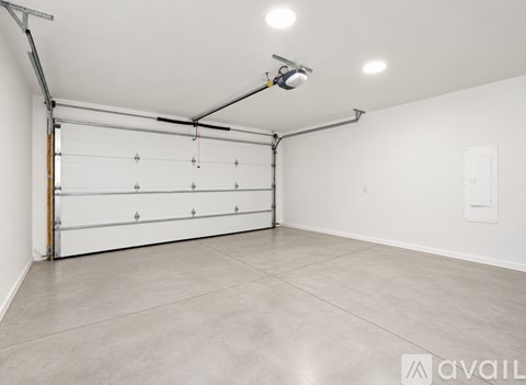 A spacious garage with a white wall and a closed white door.
