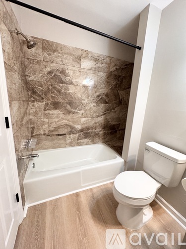 A bathroom with a tub, toilet and sink.
