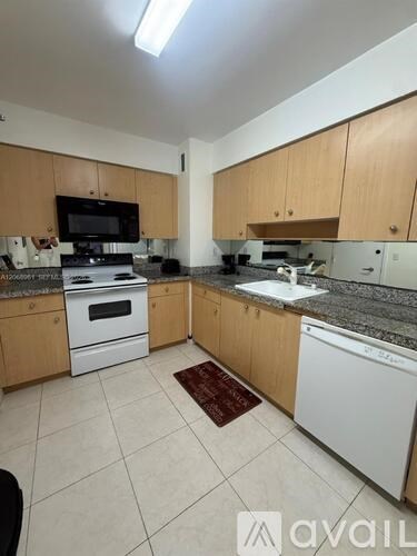 A kitchen with wooden cabinets and white appliances.