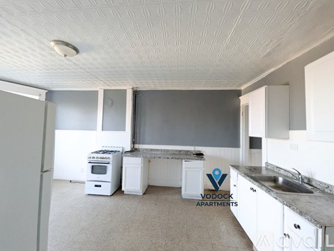 A Vodood Apartments kitchen with a refrigerator, oven, and sink.