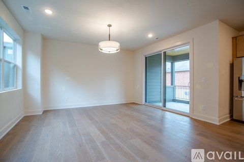 A spacious room with wooden flooring and a hanging light fixture.