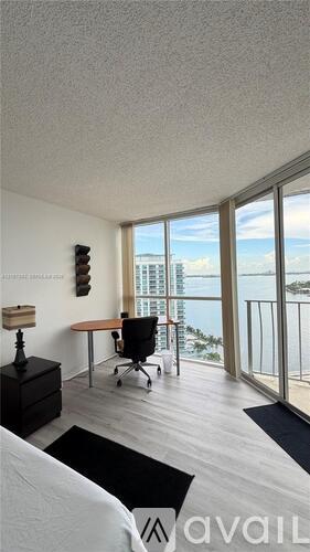 A room with a desk and a chair with a view of the outside.