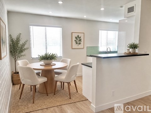 A dining room with a round table and chairs.