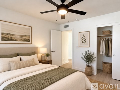 A bedroom with a large bed and a ceiling fan.