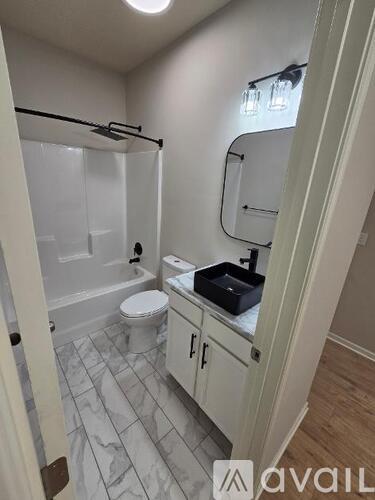 A bathroom with a toilet, sink, and shower.