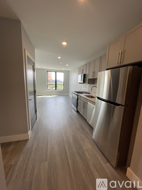 A kitchen with a refrigerator, sink, and cabinets.