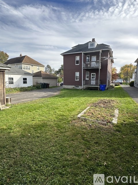 A grassy area in front of a building with a sign that says "available".