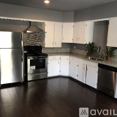 A kitchen with white cabinets and a black stove top oven.