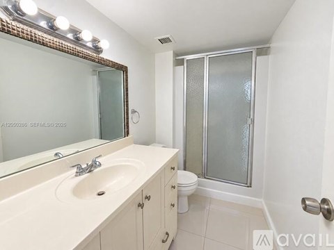 A bathroom with a sink, mirror, toilet and shower.