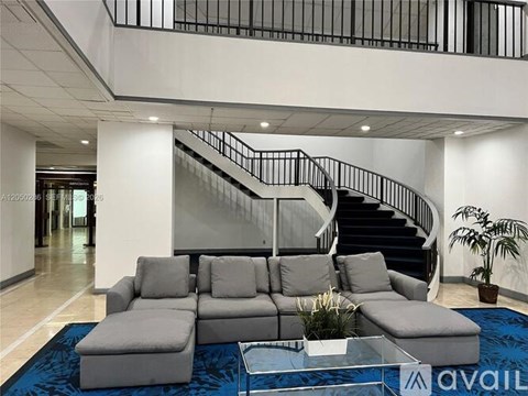 A living room with a grey sofa and a glass coffee table.