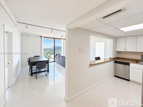 A kitchen with white cabinets and a dining table with chairs.