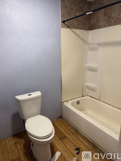 A white toilet sits next to a bathtub in a bathroom.