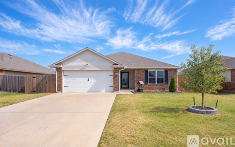 A house with a driveway and a tree in front.