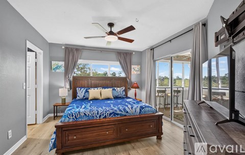 A bedroom with a large bed and a ceiling fan.