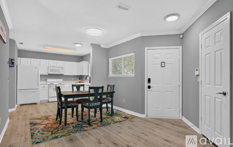 A kitchen with a dining table and chairs in the middle of the room.