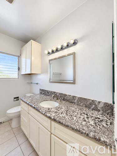 A bathroom with granite countertops and a large mirror.
