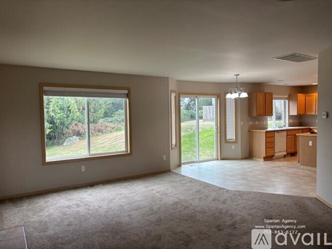 A spartan agency office with a large window and carpeted floor.