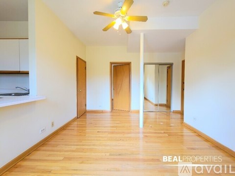 A room with wooden floors and a ceiling fan.