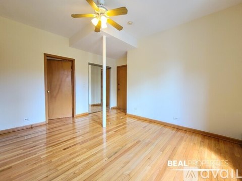 A room with a ceiling fan and wooden floors.