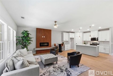 A living room with a grey couch and a black chair.