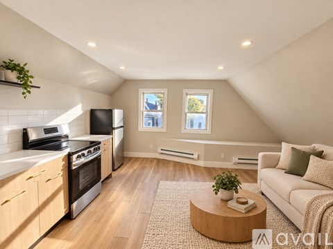 A well-lit, spacious kitchen and living room with a couch, coffee table, and windows.