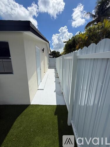 A white house with a white fence and a white walkway.
