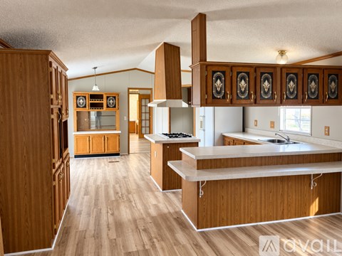 A kitchen with wooden cabinets and a large island.