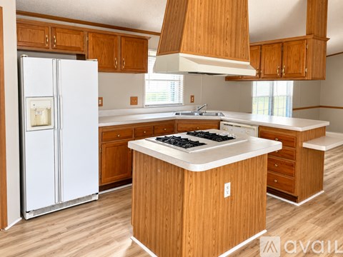 A kitchen with wooden cabinets and a white fridge.