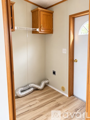 A room with a white door and a wooden cabinet.
