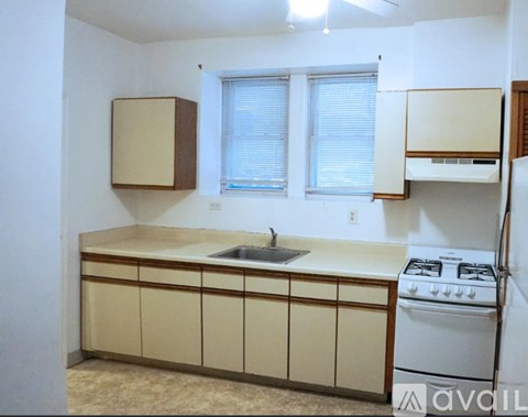 A kitchen with a white stove and beige cabinets.