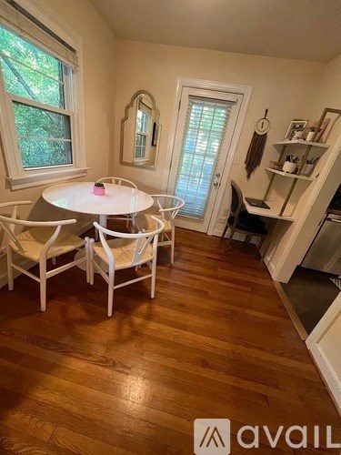 A dining room with a white table and chairs.