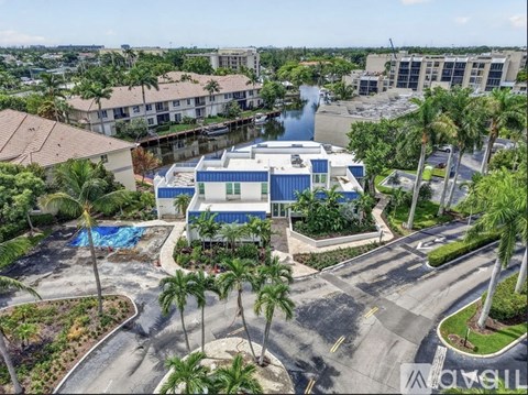 A blue and white building with a pool in front of it.