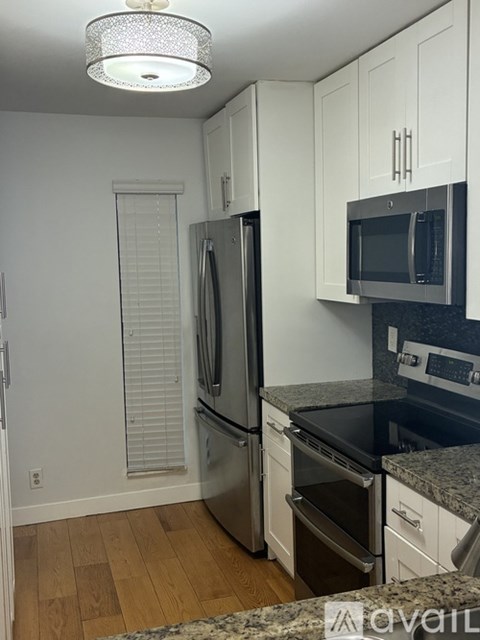 A kitchen with a stainless steel refrigerator and microwave.