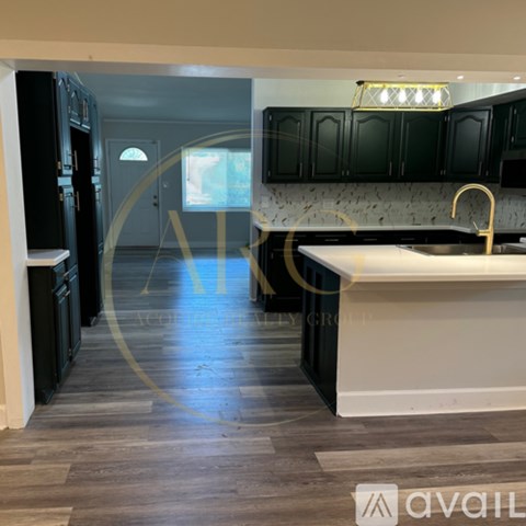 A kitchen with black cabinets and a white countertop.