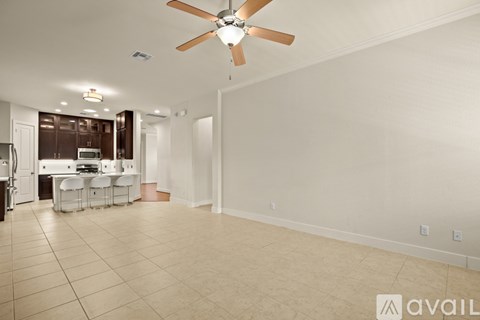 A spacious room with a ceiling fan and tiled flooring.