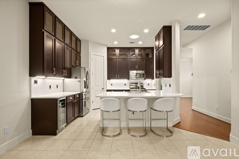 A modern kitchen with white and brown cabinets and a bar area.