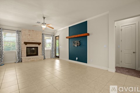 A spacious living room with a fireplace and a ceiling fan.