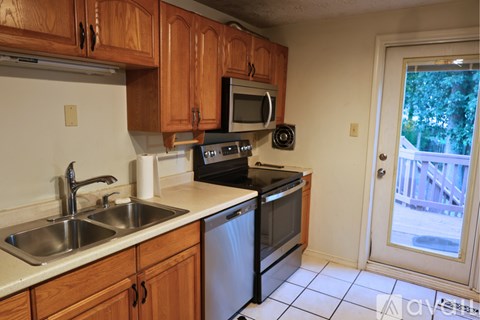 A kitchen with wooden cabinets and a black stove top oven.
