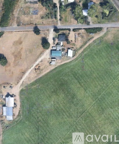 A satellite image shows a rural area with a few buildings and a road.