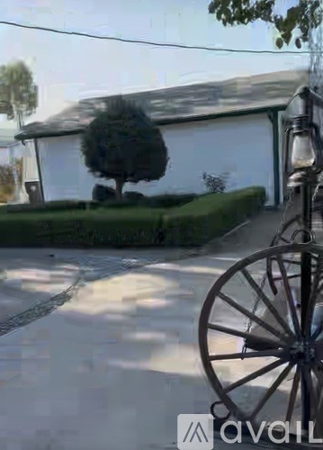A white house with a black tree in front of it.