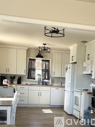 A kitchen with white cabinets and appliances.