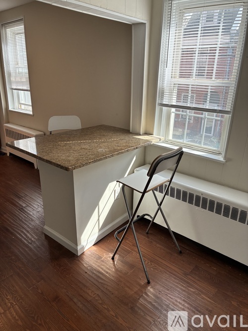 A room with a desk and chair in front of a window.