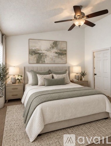 A bedroom with a large bed and a ceiling fan.