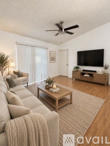 A living room with a grey couch, a wooden coffee table, and a flat screen TV.
