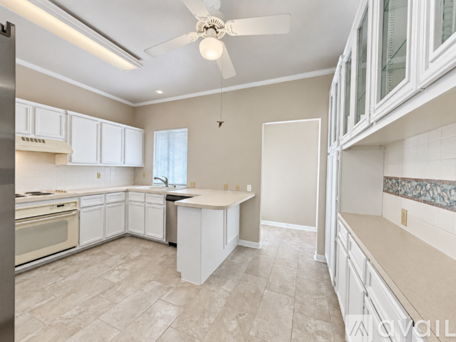 A kitchen with white cabinets and a tile floor.
