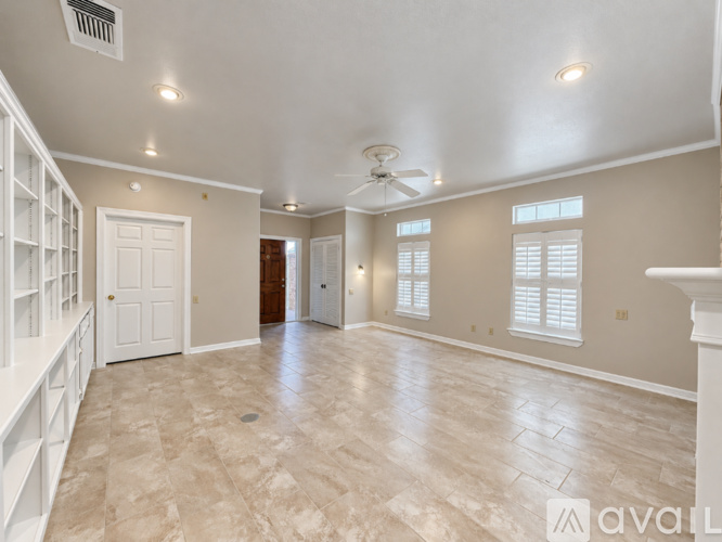 A spacious room with a tiled floor and a ceiling fan.