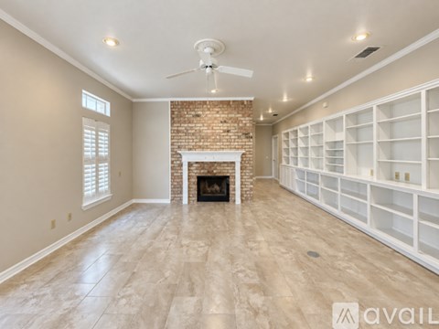 A spacious living room with a fireplace and built-in shelves.